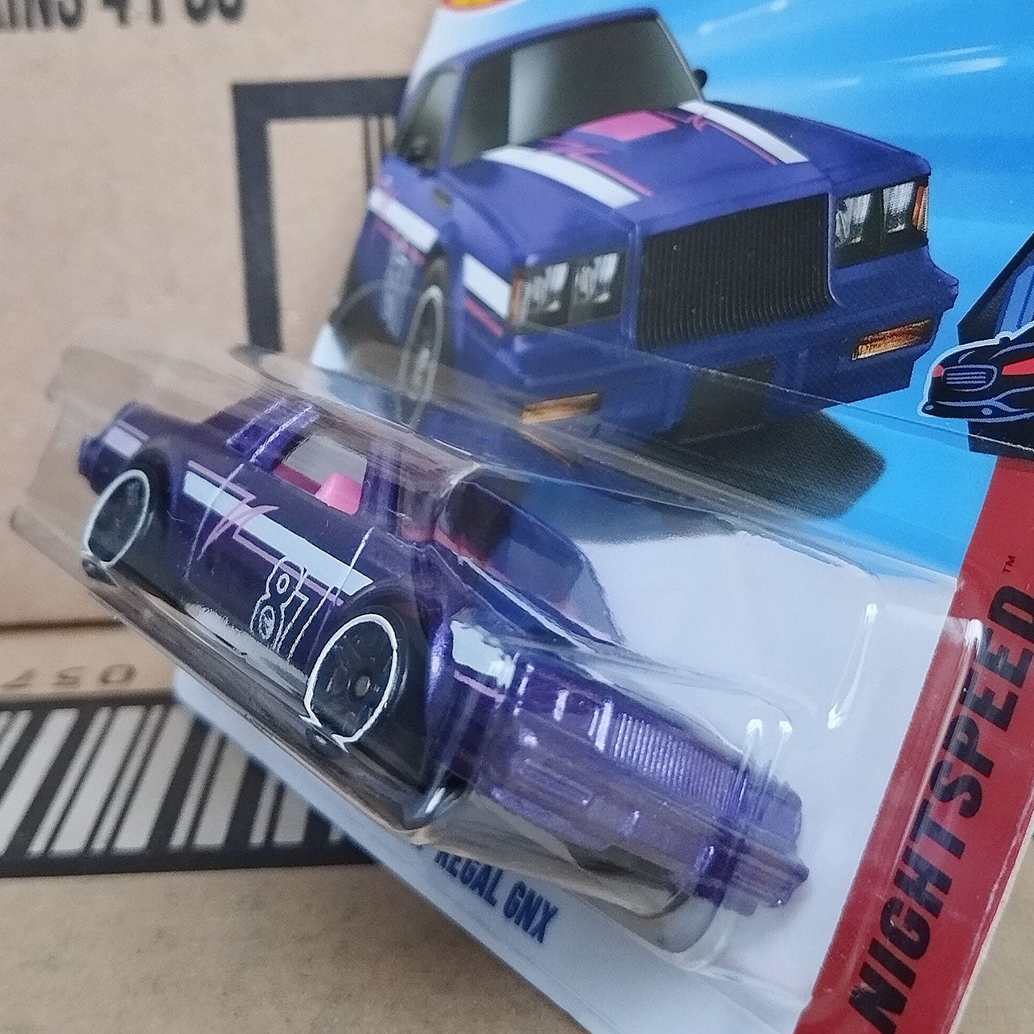 Side angled view of Hot Wheels Treasure Hunt 1987 Buick Regal GNX 1/64 diecast muscle car in factory sealed packaging