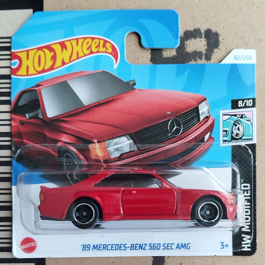 Hot Wheels 89 Mercedes-Benz 560 SEC AMG toy car in packaging on a cardboard background