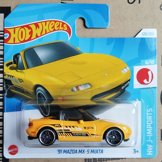 Hot Wheels J-Imports HW J-Imports '91 Mazda MX-5 Miata toy car in its original blister card packaging, featuring a bright yellow convertible with black and gray racing decals.