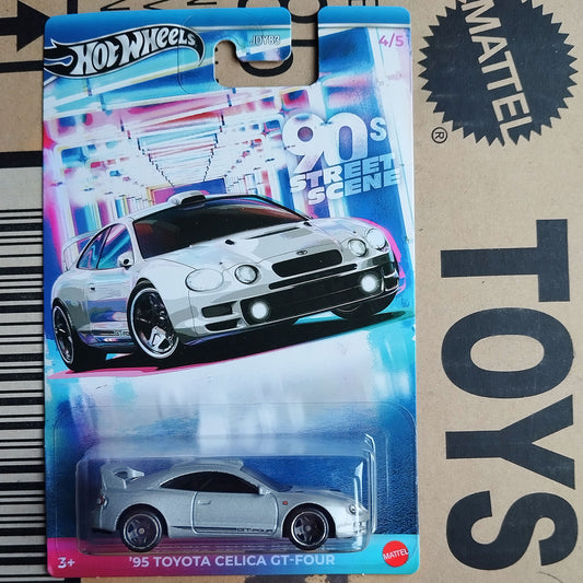 Hot Wheels Mattel '95 Toyota Celica GT-Four toy car in its original blister card packaging, displayed next to a cardboard box with 'TOYS' printed on it.