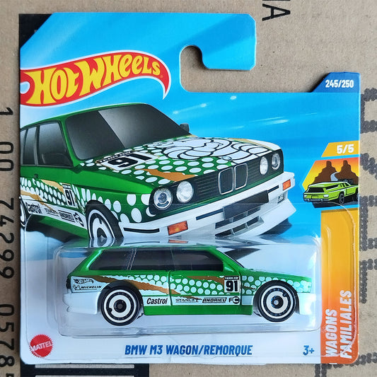 Hot Wheels toy car of a BMW M3 wagon with a green and white spotted pattern, mounted on its original blue and yellow blister card packaging.