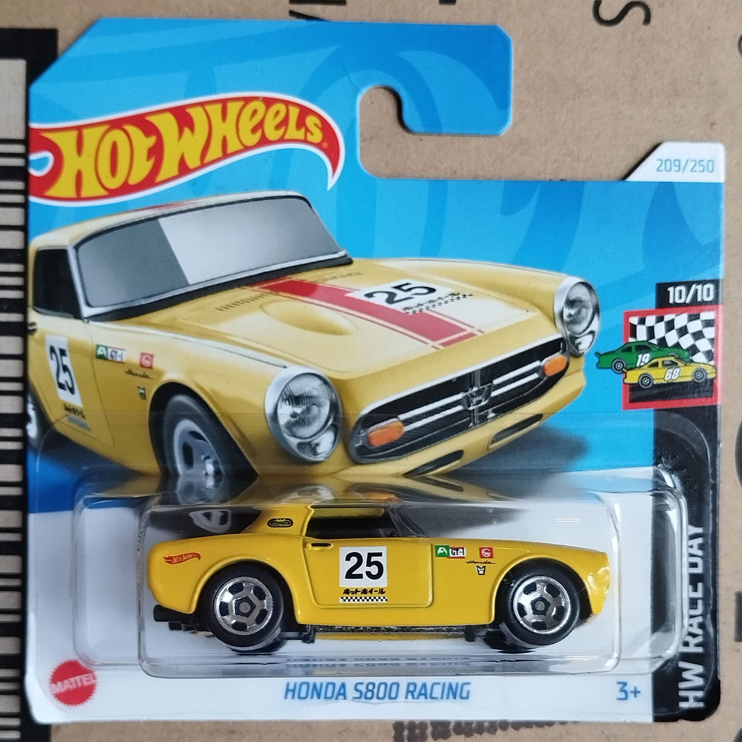 Hot Wheels die-cast toy car package featuring a yellow Honda S800 Racing model car in clear blister packaging, with the Hot Wheels logo and card art on a cardboard backing.