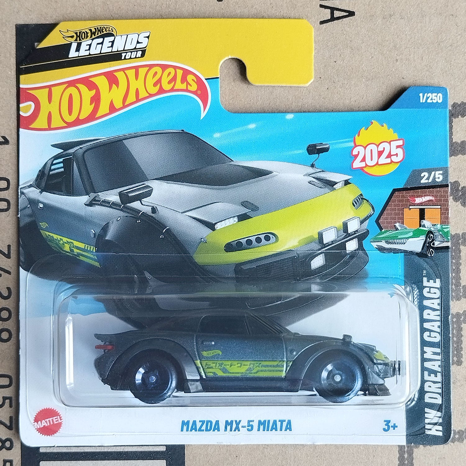 Hot Wheels Legends Toys 2025 Mazda MX-5 Miata die-cast toy car in its original carded packaging, featuring a black and lime green car design.