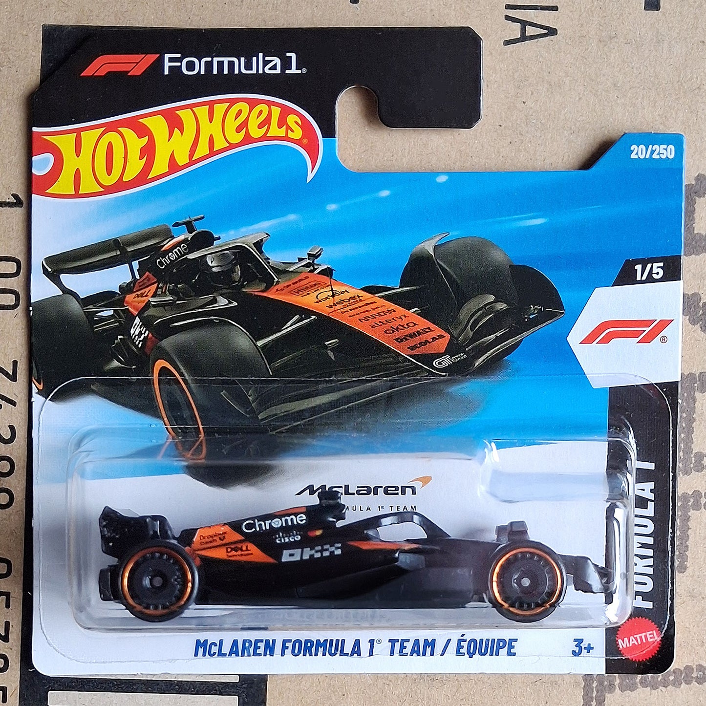 A Hot Wheels Mattel Formula 1 die-cast toy car in its original blister packaging, featuring a McLaren Formula 1 Team car in black and orange livery.