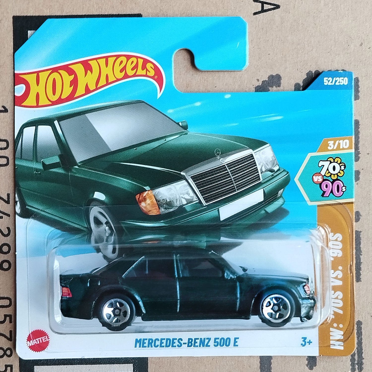 Hot Wheels Mercedes-Benz 500E green color diecast 1/64 car in original packaging on cardboard background