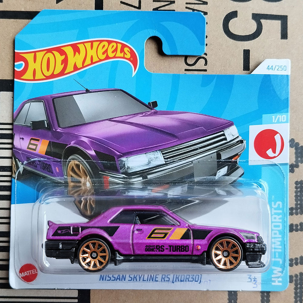 A Hot Wheels toy car of a purple Nissan Skyline RS (Kuro) with gold wheels, displayed in its original blue blister pack packaging.