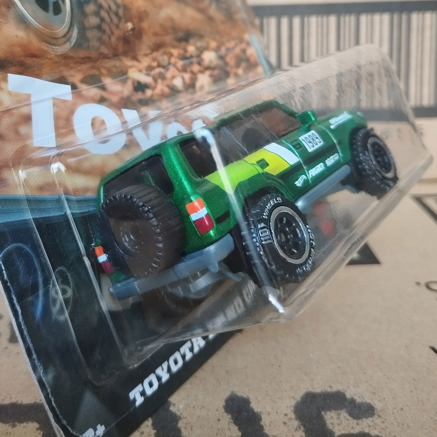 Rear angled view of Hot Wheels Toyota Land Cruiser 80 green 1/64 diecast off-road SUV in Silver Series packaging