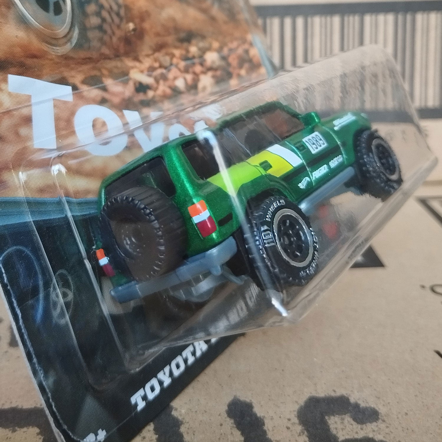 Rear angled view of Hot Wheels Toyota Land Cruiser 80 green 1/64 diecast off-road SUV in Silver Series packaging