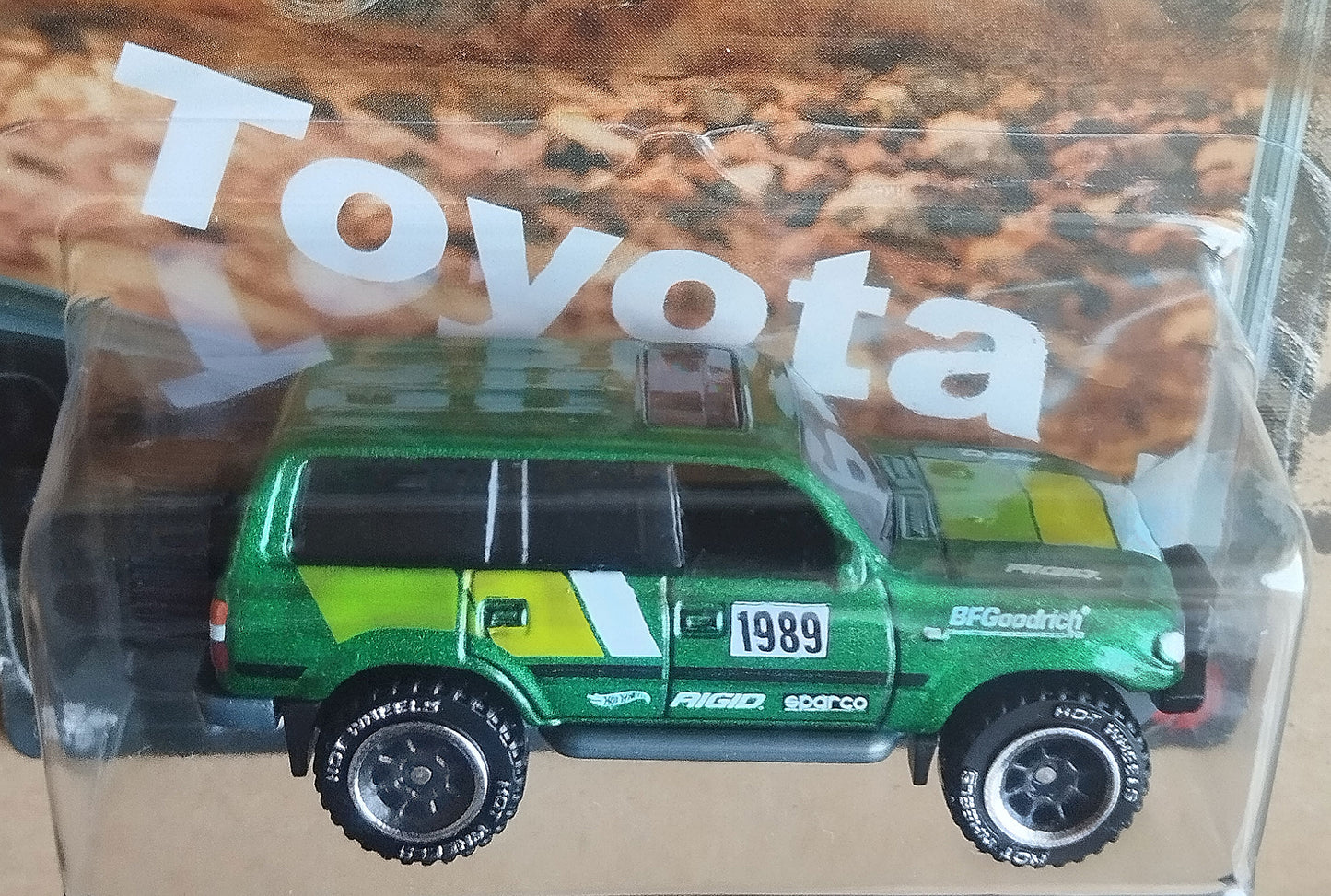 Close-up side view of Hot Wheels Toyota Land Cruiser 80 green 1/64 diecast off-road JDM SUV in packaging
