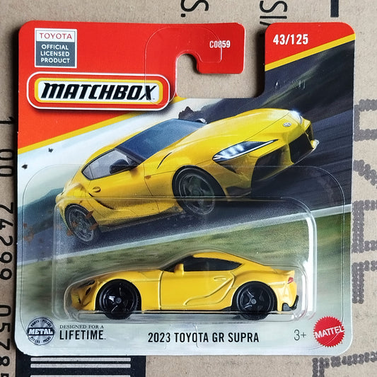 Matchbox 2023 Toyota GR Supra die-cast toy car in its original blister card packaging, featuring a bright yellow car with black wheels and a red and white card backing.