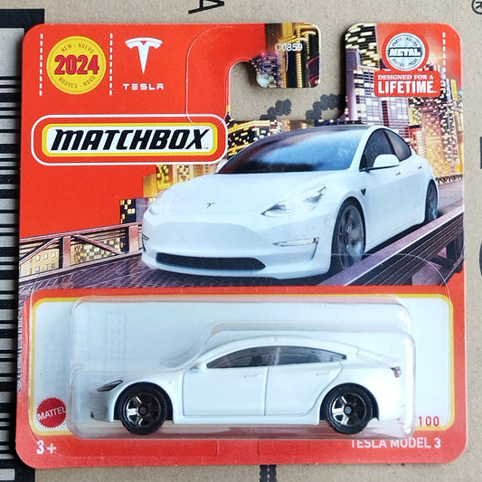 Matchbox Mattes Tesla Model 3 toy car in its original red blister card packaging, featuring a white die-cast model car and a printed illustration of a white Tesla on the card.